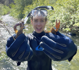 Image of Claire Vaage on the John Day River basin in Oregon with crayfish samples.